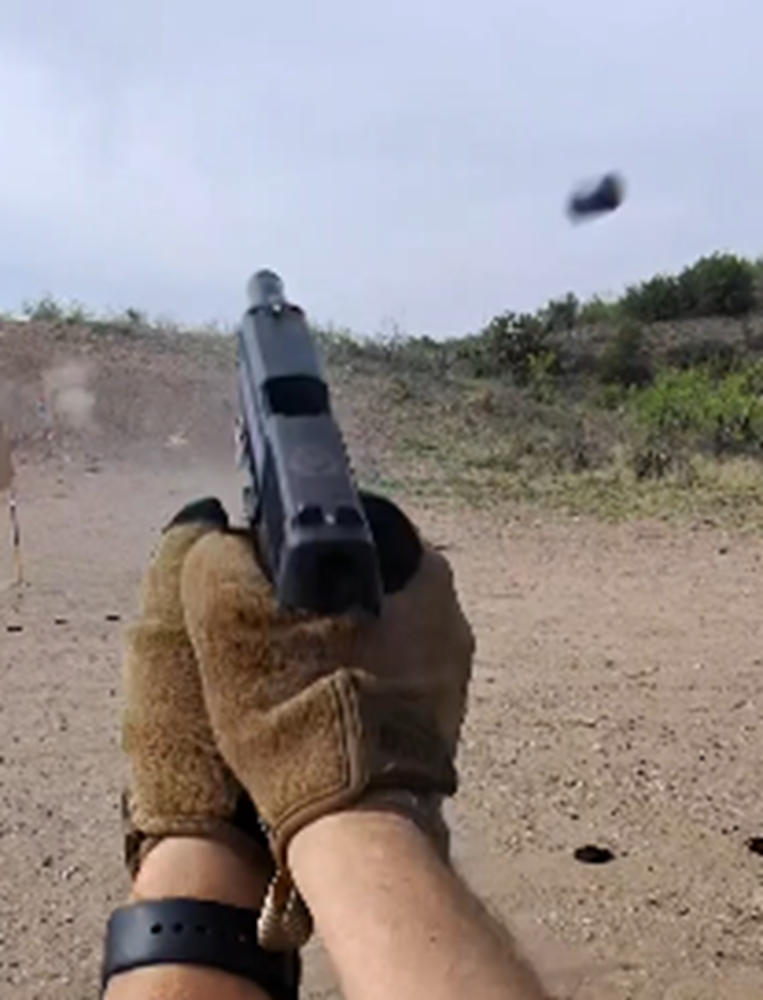 Pistol fired at the range with brass in the air