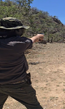 Shooter firing a pistol outdoors